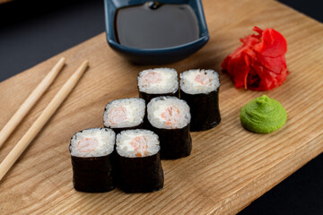 Simple salmon sushi rolls served on wooden dish, minimalist studio photo for a menu