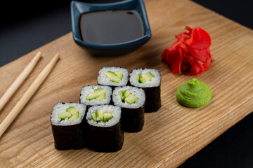 Light and dietary sushi with cucumber, rice and nori in a dark restaurant