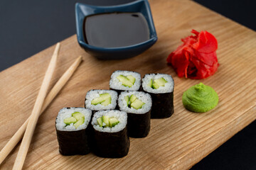 Light and dietary sushi with cucumber, rice and nori in a dark restaurant
