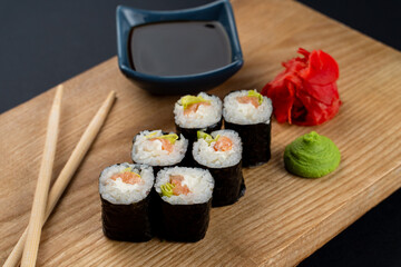 Salmon rolls served with soy sauce boat, fermented ginger and wasabi