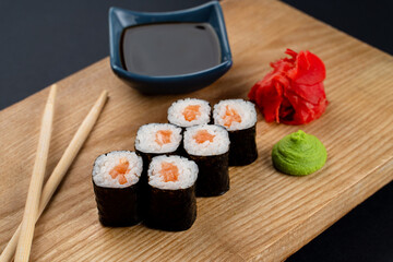 Salmon rolls served with soy sauce boat, fermented ginger and wasabi