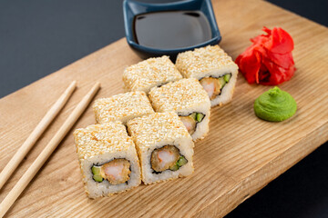 Warm and crispy prawns and avocado sushi roll set on wooden board