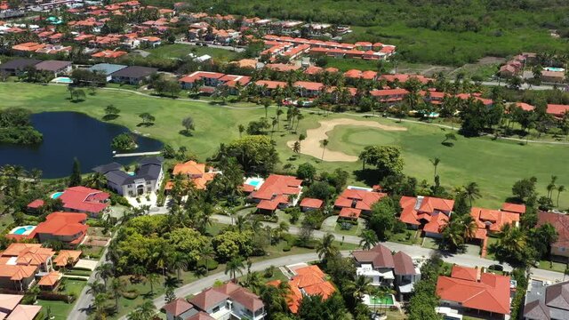 Golf course with roads, coconut palm trees and houses. Aerial view. Dominican Republic