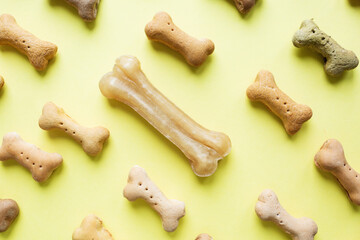 Small colored Dog Bones pattern on yellow wallpaper background.