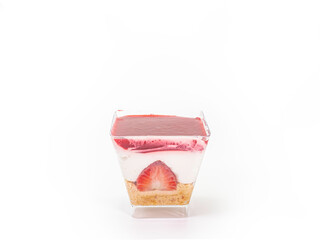 The close up of strawberry cheesecake in transparent plastic square shape cup isolated on white background.