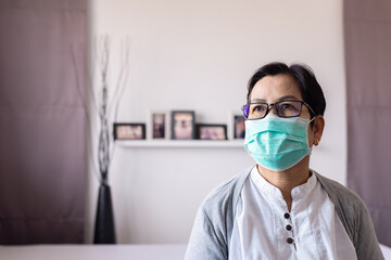 Elderly asian women wearing surgical masks protect corona virus or covid-19 during spreading at home,Social distancing,New normal,Coronavirus protection face mask