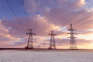 Power lines during a beautiful winter sunset in pink shades.