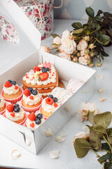 Preparing care package, seasonal gift box with cape cake and roses. Personalized eco friendly basket for holidays. Concept valentine day. Top view, flat lay