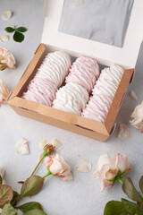 Preparing care package, seasonal gift box with marshmallow, roses. Personalized eco friendly basket for winter holidays. Concept valentine day. Top view, flat lay