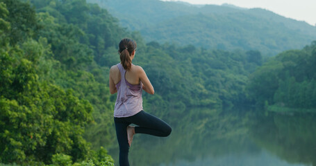 Woman do yoga at country park