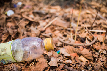 Sumba,Indonesia-September 2020: Plastic bottle garbage on a ground full of dry leaves