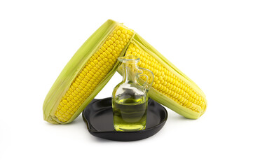 Corn oil in decanter and fresh corncobs