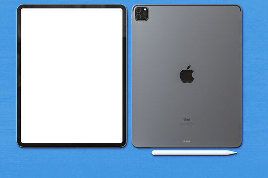new Apple iPad pro 2020 space gray ,blank white display screen and rear view logo with apple pencil. Isolate on blue background. Illustrative editorial