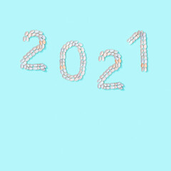 Naklejka premium Figure 2021 laid out of small similar natural seashells on blue paper. Summer design concept with shells