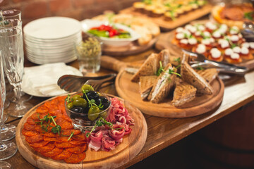 Beautifully decorated catering banquet table with different food snacks and appetizers on corporate christmas birthday party event or wedding celebration