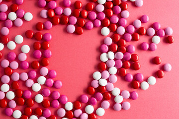 pink, white, and red chocolage candies on a red background