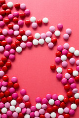 pink, white, and red chocolage candies on a red background