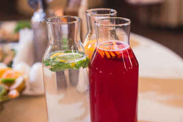 View of alcohol setting on catering banquet table, row line of different colored alcohol cocktails on a party, martini, vodka, spritz and others on decorated catering table event