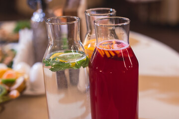 View of alcohol setting on catering banquet table, row line of different colored alcohol cocktails on a party, martini, vodka, spritz and others on decorated catering table event