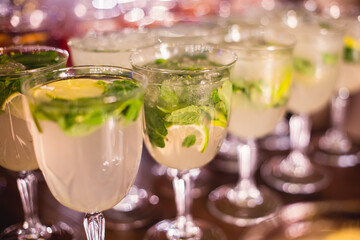 View of alcohol setting on catering banquet table, row line of different colored alcohol cocktails on a party, martini, vodka, spritz and others on decorated catering table event
