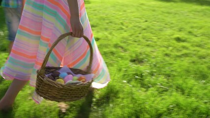 Two children boy and girl having easter egg hunt in garden backyard