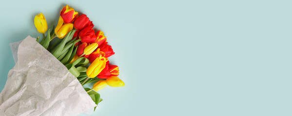 Bouquet Red Yellow tulips flowers on blue background. Waiting for spring, seasonal holiday. Happy Easter card, 8 march Woman International Day. Flat lay, top view, copy space, banner, flyer