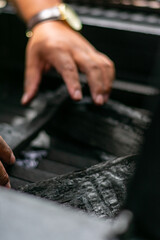 manos encendiendo carbón para un asado , fuego en asador , grill , fuego 