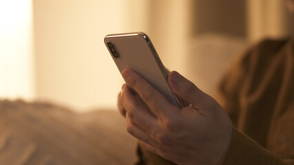 夜、スマートフォンを操作する男性