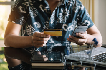 businesswoman hand using smart phone, tablet payments and holding credit card online shopping, omni channel, digital tablet docking keyboard computer at office in sun light