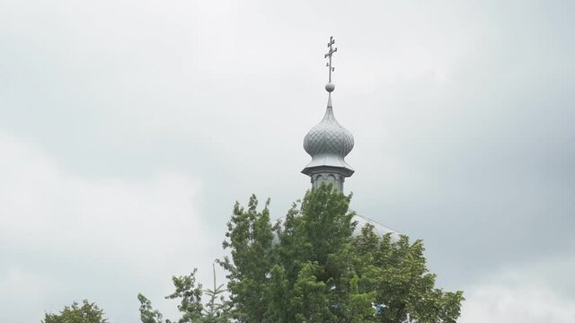 Christian cross on the dome of an Orthodox church. Large white stone temple