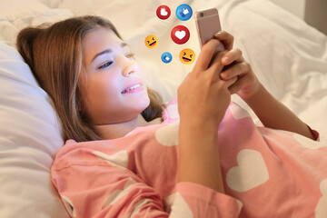 Cute teenage girl using mobile phone for social networking at home