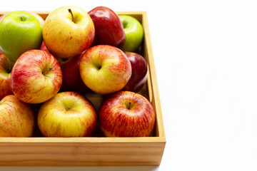 Fresh apples in wooden box on white background.