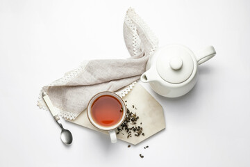 Composition with teapot and cup of tea on white background