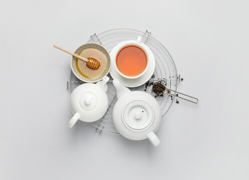 Composition with teapots, cup of tea and honey on white background © Pixel-Shot