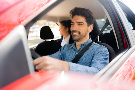 Taxi driver with passenger at back seat.