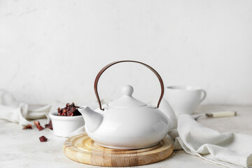 Teapot and dry tea leaves on table