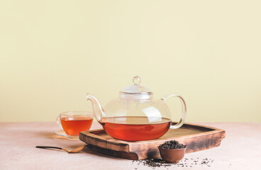Glass teapot and cup of tea on table