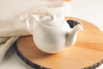 Teapot and dry tea leaves on table