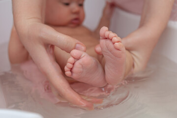 baby feet in the bathroom, mom bathes daughter