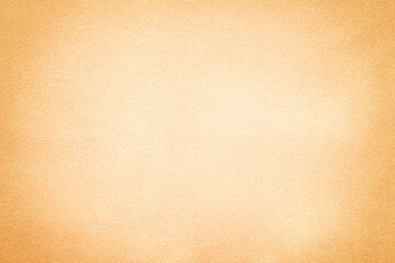 Beige matte background of suede fabric with vignette, closeup. Velvet textile.