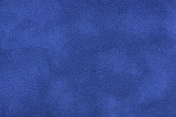 Navy blue matte background of suede fabric, closeup. Velvet texture of textile.