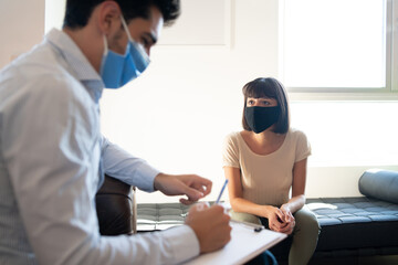 Psychologist taking notes during therapy session.