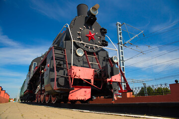 Obraz premium Old steam locomotive against the blue sky.