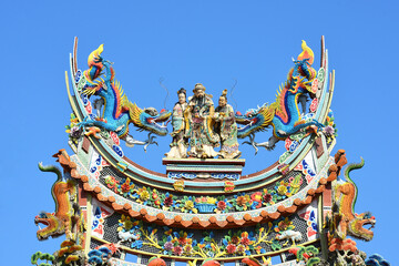 Fototapeta na wymiar Chinese traditional temple roofs .Bright multi-colored sculptures of Chinese god on the roof