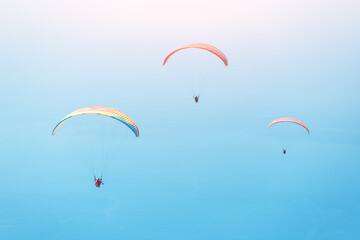 Team of paragliders flying in the blue sky. Extreme and air activity and sport concept. Takeoff from famous spot on Babadag mountain