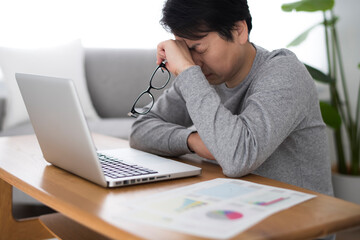 テレワークで頭を抱える男性