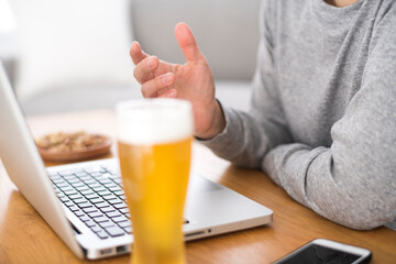 自宅でオンライン飲み会をしている男性