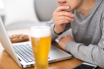 自宅でオンライン飲み会をしている男性