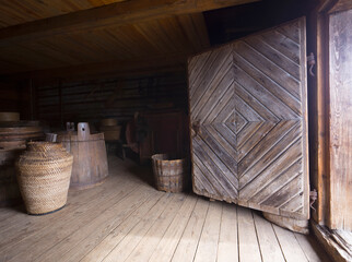 Wooden barrels and grain storage tanks in the Ambar. Interior in Barn. Russian village