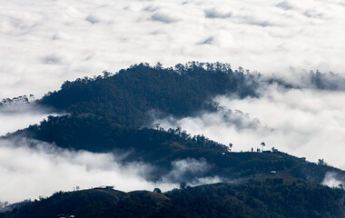Aerial view over mountain range covered with fog and cloud.